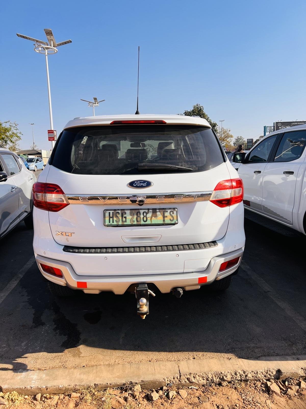 Rear of the white Ford Everest XLT, showing the XLT badge, parking sensors and fitted tow bar