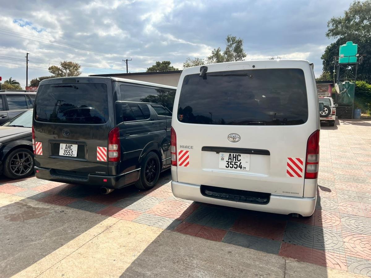 Both Local Legends Toyota Hiace minibuses parked side by side, charcoal and silver