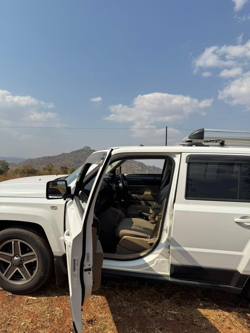 The Jeep Patriot with the driver’s door open, showing the cabin and seats