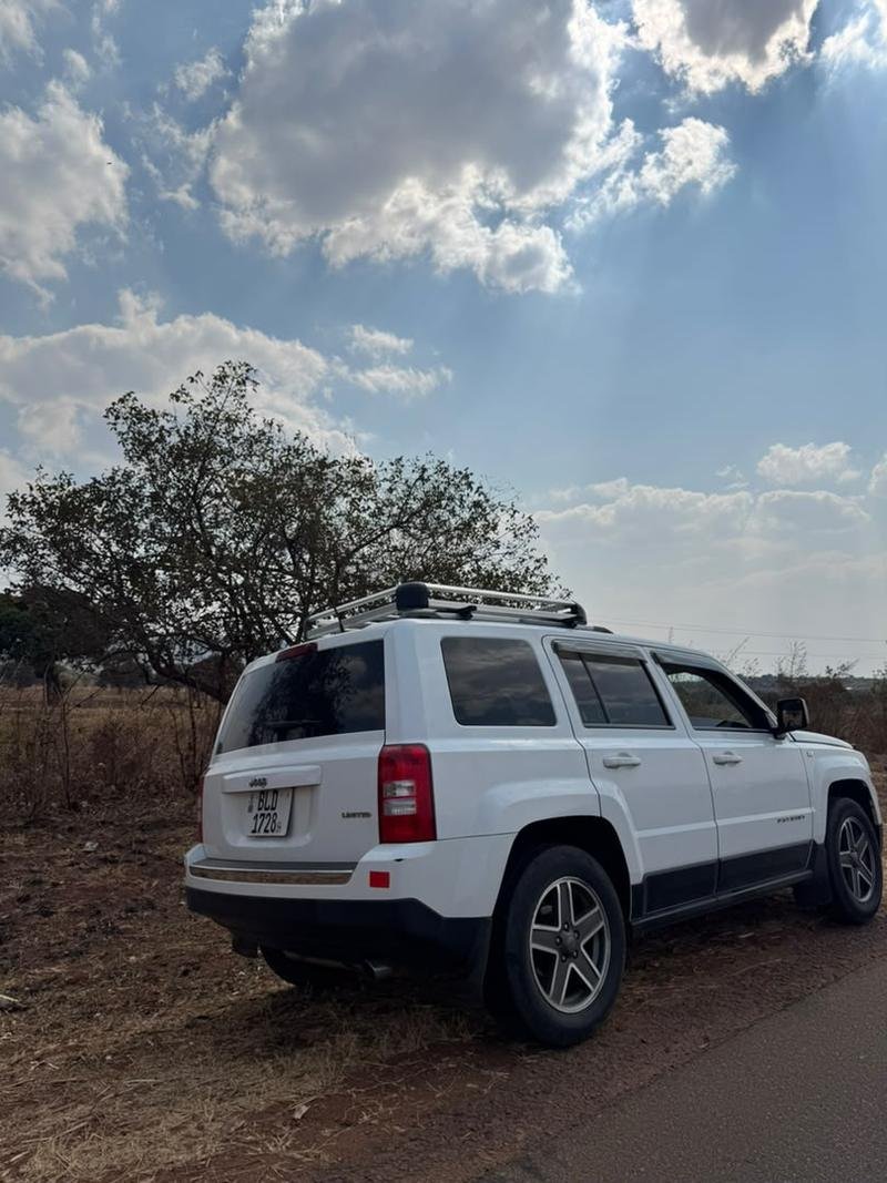 Rear three-quarter view of the white Jeep Patriot with the roof carrier fitted
